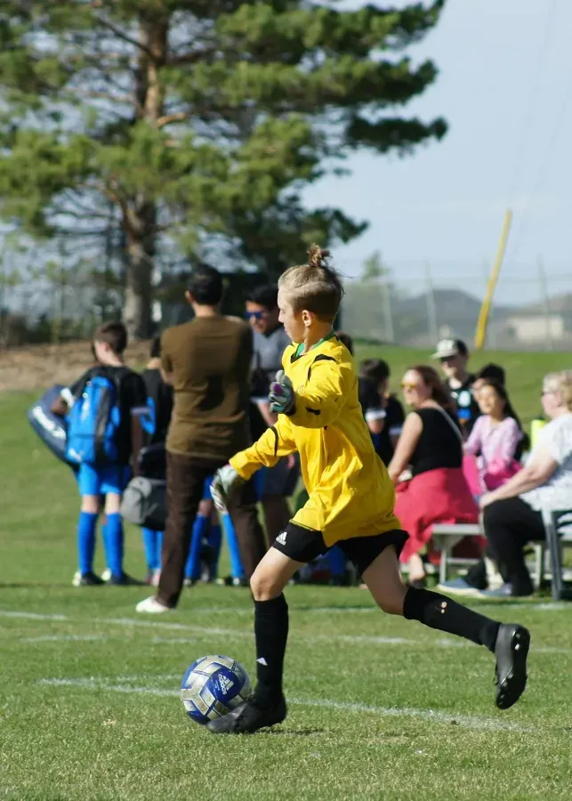 A child running with a football on a grass field